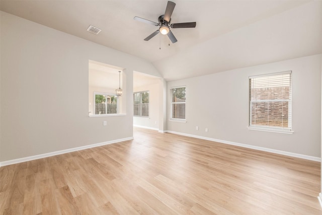 spare room featuring visible vents, light wood-style flooring, plenty of natural light, and ceiling fan with notable chandelier