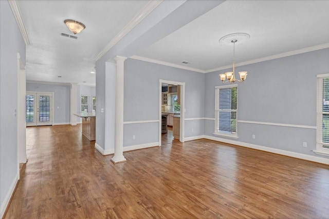 unfurnished dining area with crown molding, baseboards, wood finished floors, and visible vents