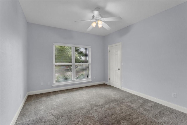 carpeted empty room featuring a ceiling fan and baseboards