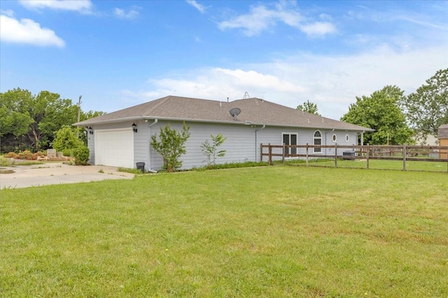 view of property exterior featuring a lawn, an attached garage, fence, and driveway