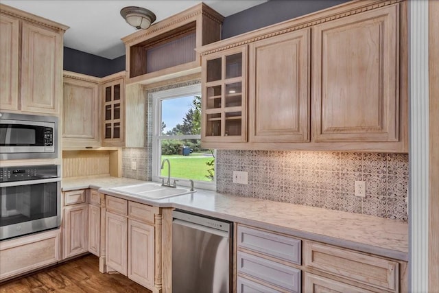 kitchen featuring light countertops, stainless steel appliances, a sink, and light brown cabinets