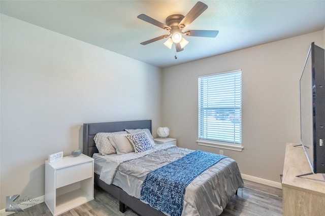 bedroom featuring baseboards, a ceiling fan, and wood finished floors