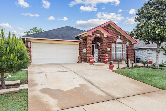 view of front of property with roof with shingles, an attached garage, brick siding, a front yard, and driveway
