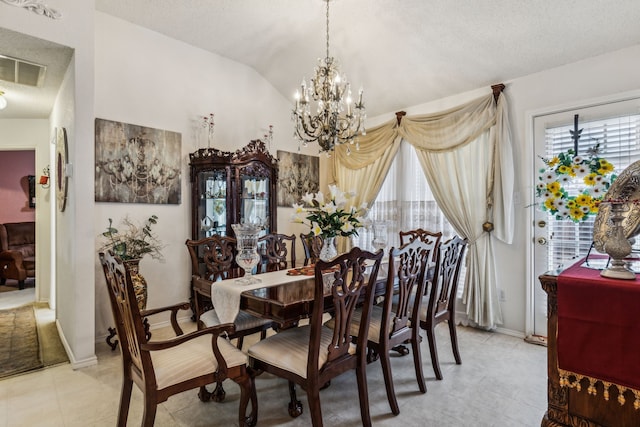 dining room with a healthy amount of sunlight, visible vents, lofted ceiling, and a chandelier
