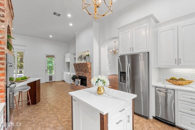 10535 Longfellow Trce, Shreveport, LA 71106 - kitchen with appliances with stainless steel finishes, a chandelier, a brick fireplace, crown molding, and tasteful backsplash