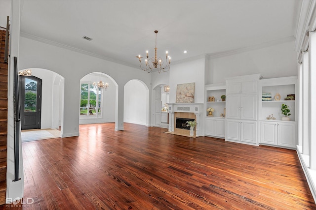 10535 Longfellow Trce, Shreveport, LA 71106 - unfurnished living room featuring a chandelier, arched walkways, hardwood / wood-style floors, ornamental molding, and a fireplace with flush hearth