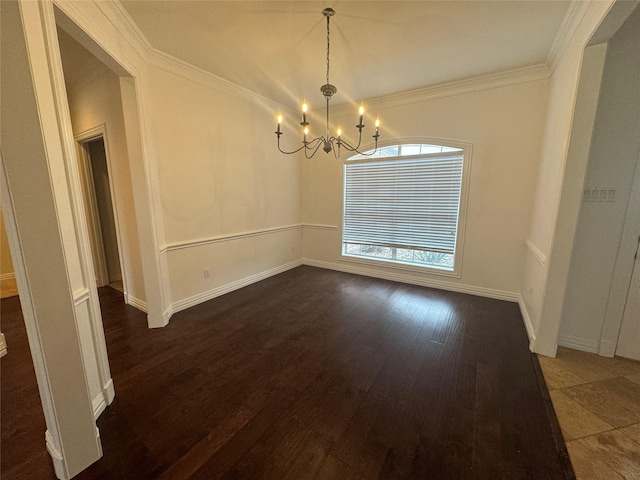 unfurnished dining area featuring baseboards, ornamental molding, wood finished floors, and a chandelier