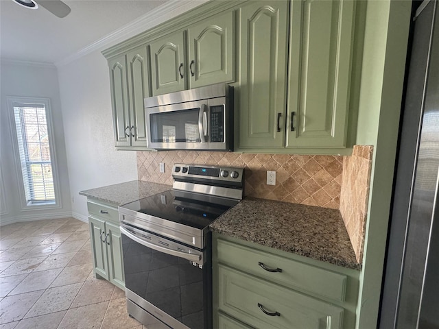 kitchen featuring appliances with stainless steel finishes, tasteful backsplash, baseboards, ornamental molding, and green cabinetry
