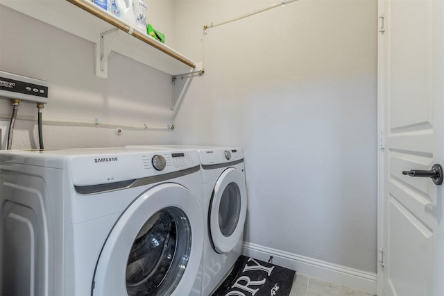 laundry area with laundry area, baseboards, tile patterned flooring, and separate washer and dryer