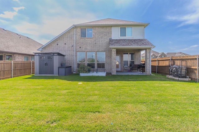 back of property with an outdoor structure, a fenced backyard, brick siding, a patio area, and a storage shed