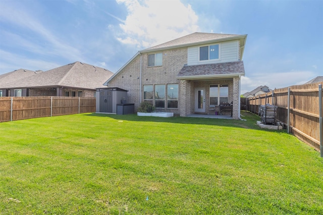 back of property featuring a storage shed, a patio, a yard, and a fenced backyard