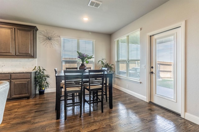dining area featuring baseboards, dark wood-type flooring, and visible vents