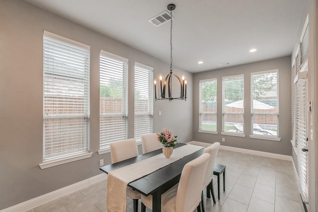 dining room featuring baseboards, a notable chandelier, light tile patterned flooring, and visible vents