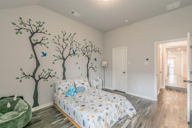 bedroom featuring baseboards, wood finished floors, and visible vents