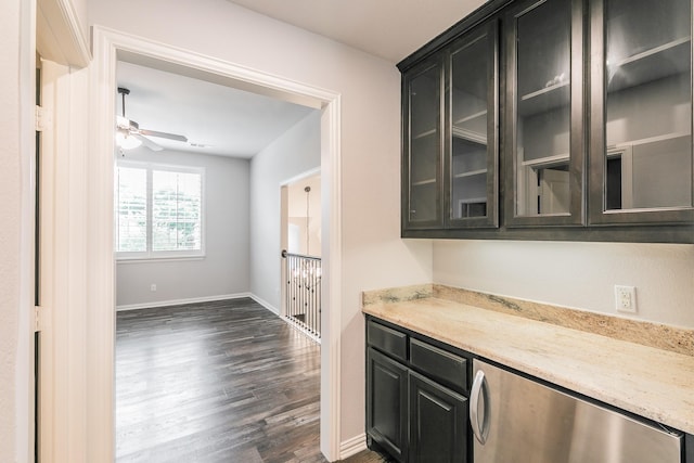 bar featuring dishwashing machine, baseboards, ceiling fan, and dark wood finished floors