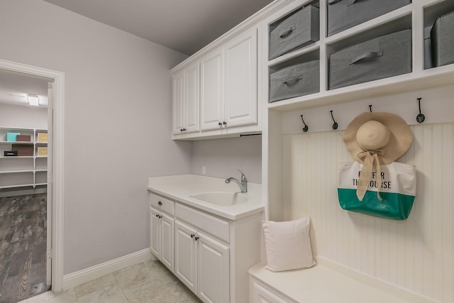mudroom featuring baseboards and a sink