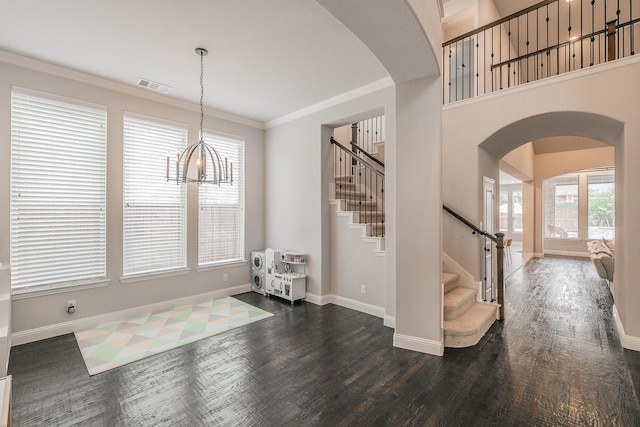 entrance foyer featuring arched walkways, baseboards, stairs, and visible vents