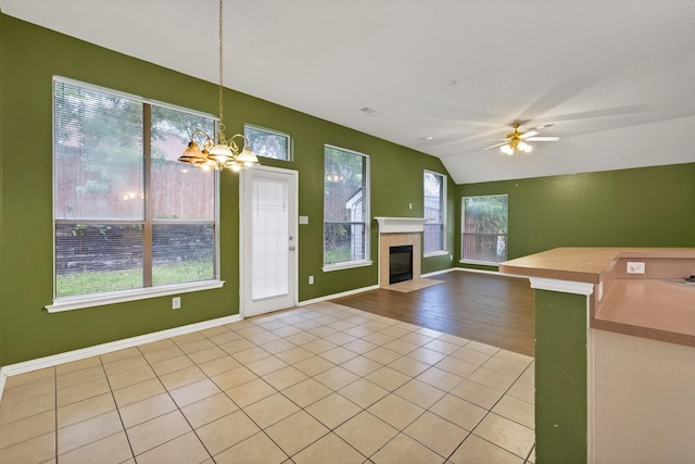 520 Jeff Grimes Blvd, Desoto, TX 75115 - unfurnished living room with a healthy amount of sunlight, a tiled fireplace, ceiling fan with notable chandelier, and lofted ceiling