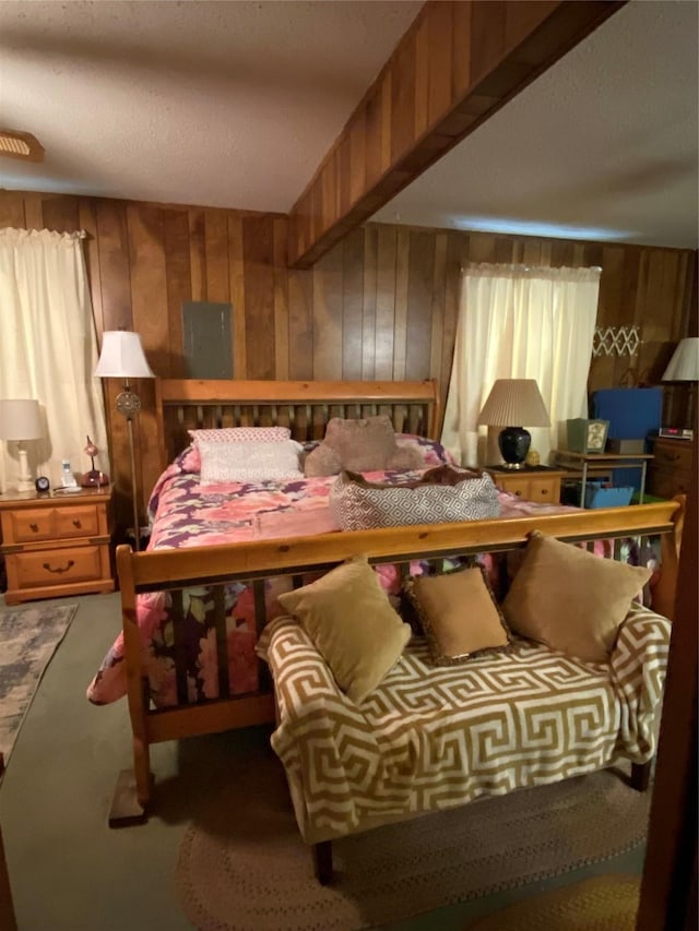carpeted bedroom featuring wood walls