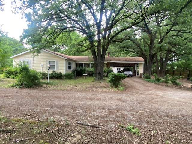 single story home featuring fence, an attached carport, and driveway