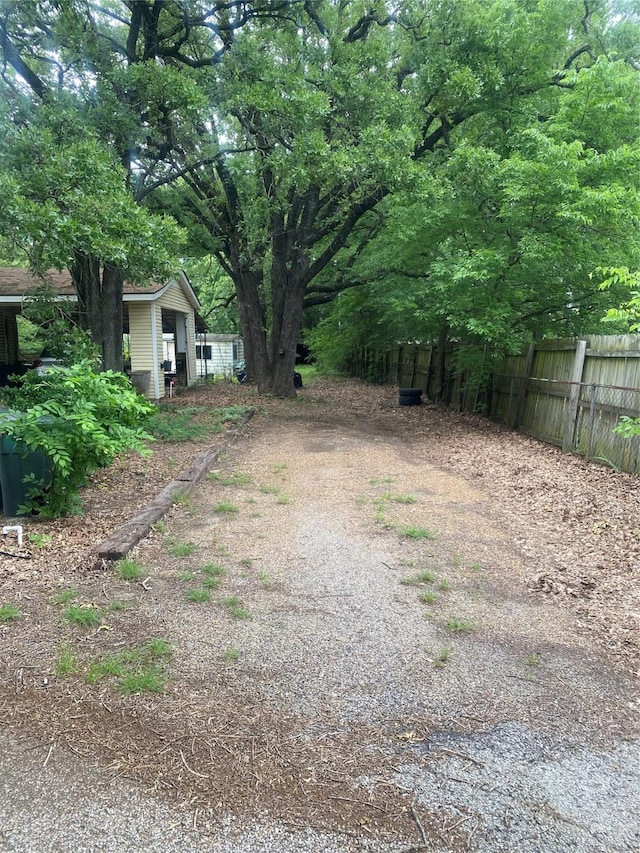 view of yard with fence and driveway