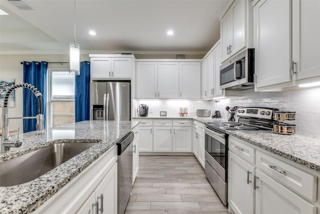 kitchen featuring visible vents, white cabinetry, a sink, appliances with stainless steel finishes, and backsplash