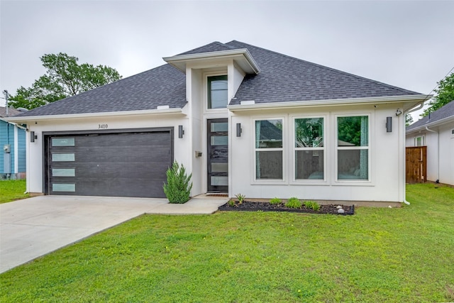 view of front of house featuring driveway, a front yard, roof with shingles, fence, and an attached garage