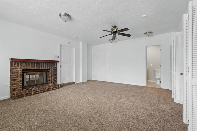 unfurnished living room featuring a brick fireplace, baseboards, ceiling fan, a textured ceiling, and carpet