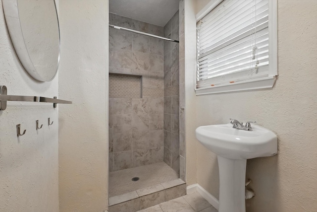 full bathroom with baseboards, a sink, and a stall shower