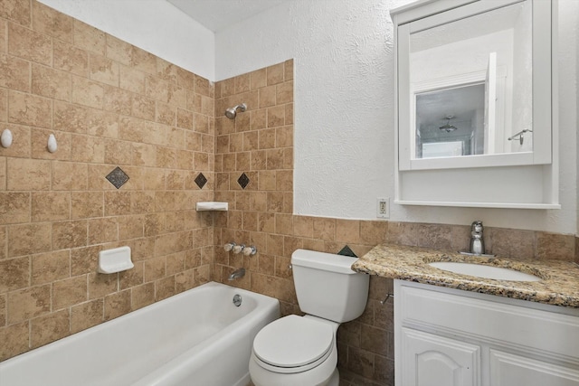 full bathroom with tile walls, wainscoting, vanity, toilet, and  shower combination