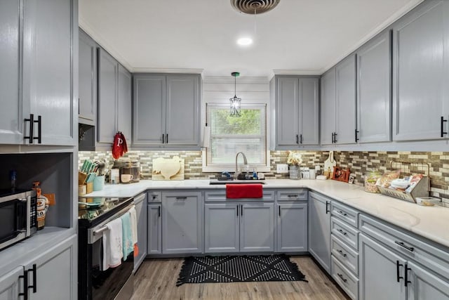 2019 W Belclaire Cir, Corsicana, TX 75110 - kitchen with light wood-style floors, a sink, appliances with stainless steel finishes, and gray cabinetry