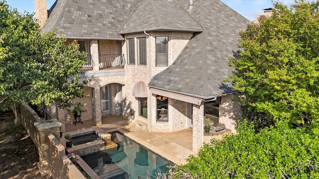 1304 Regency Ct, Southlake, TX 76092 - back of house with a balcony, a chimney, a patio area, brick siding, and an outdoor pool