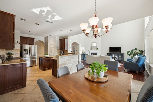 dining room with visible vents, arched walkways, and a notable chandelier