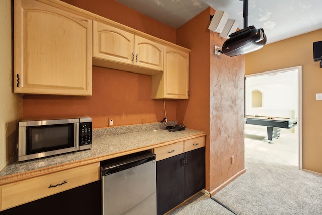kitchen featuring light colored carpet, stainless steel microwave, light brown cabinets, and fridge