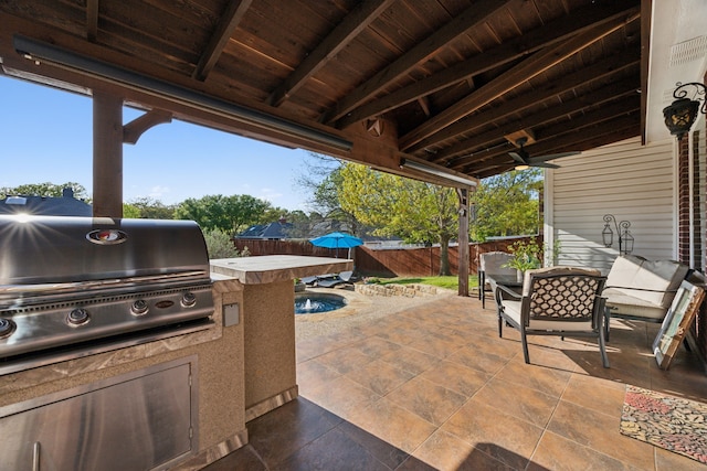view of patio / terrace with a grill, an outdoor kitchen, and a fenced backyard