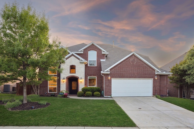 traditional-style home featuring brick siding, a garage, concrete driveway, roof with shingles, and a front lawn