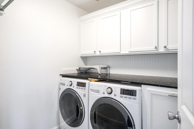clothes washing area with cabinet space and washer and clothes dryer