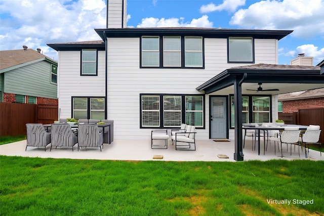 back of property featuring a lawn, ceiling fan, fence, and a patio