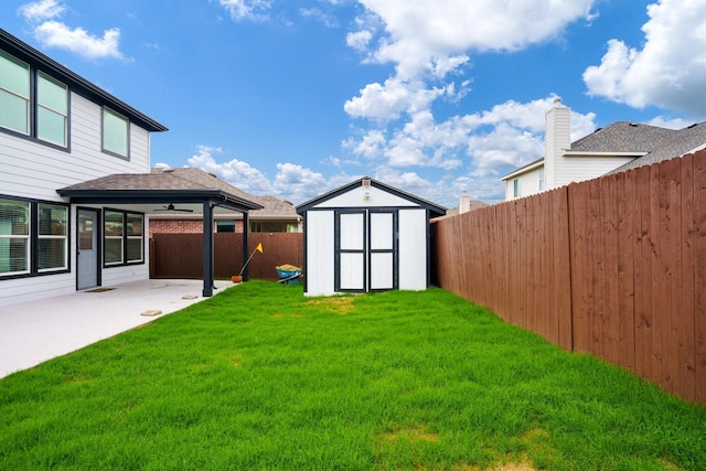view of yard featuring a fenced backyard, an outdoor structure, a patio area, and a shed
