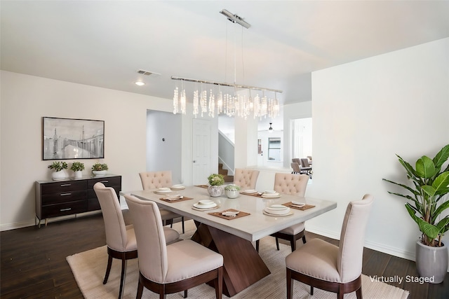 dining area with baseboards, dark wood-style flooring, a chandelier, and visible vents