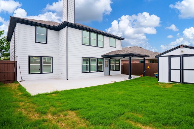 rear view of house with a patio, a fenced backyard, a yard, and a storage unit