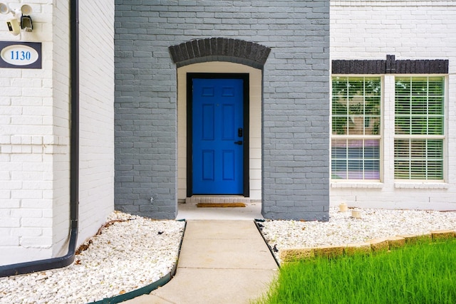 entrance to property featuring brick siding
