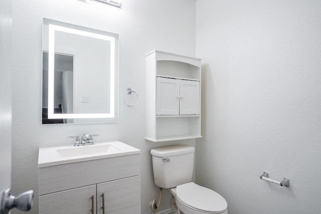 half bathroom featuring toilet and vanity