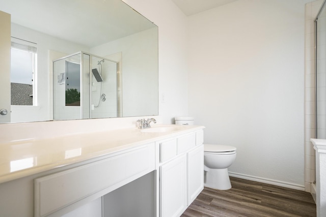full bath with vanity, wood finished floors, toilet, baseboards, and a stall shower