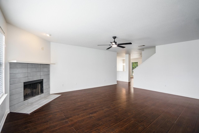 unfurnished living room with baseboards, ceiling fan, wood finished floors, and a tile fireplace