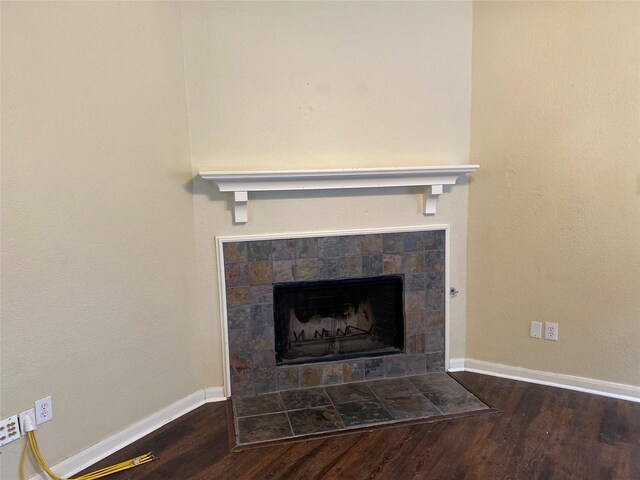interior details featuring baseboards, wood finished floors, and a tile fireplace