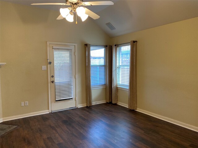 empty room featuring visible vents, lofted ceiling, baseboards, a ceiling fan, and dark wood finished floors