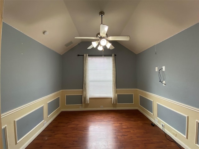 unfurnished room featuring visible vents, a ceiling fan, dark wood finished floors, and wainscoting