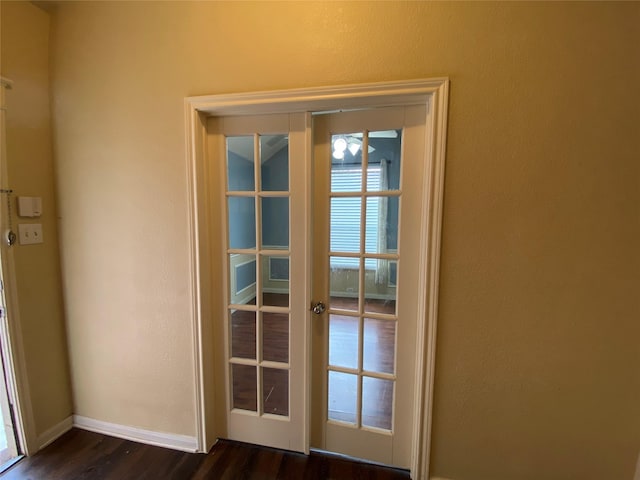 doorway featuring baseboards, a textured wall, french doors, and dark wood-type flooring