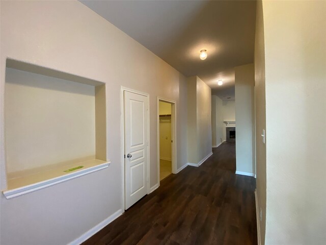 hallway with baseboards and wood finished floors
